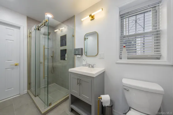 a bathroom with a sink a toilet and shower