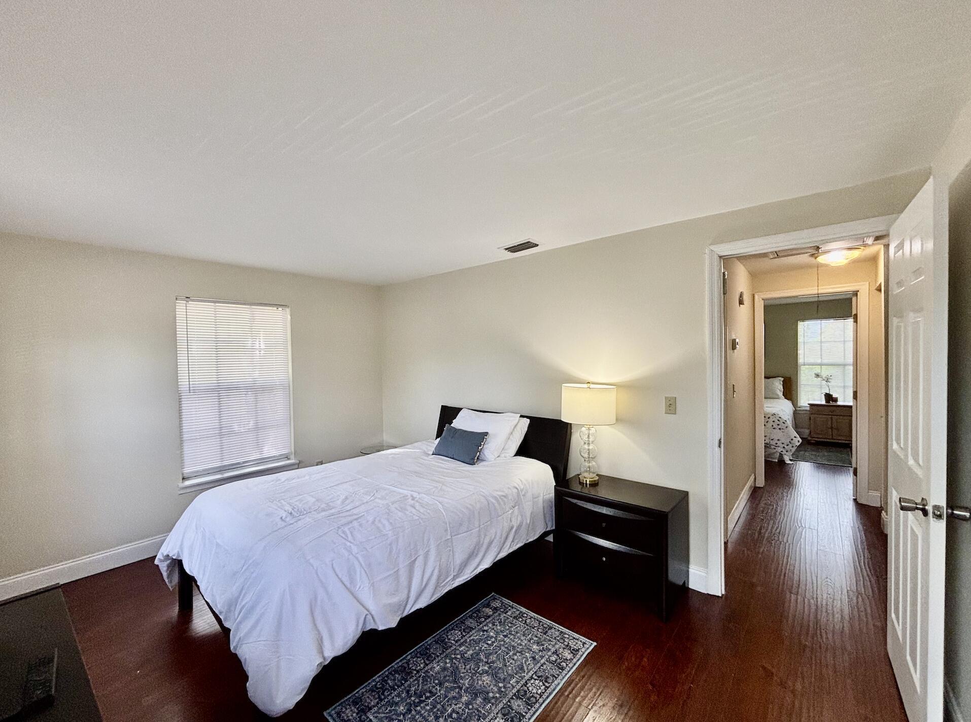 13472 Old Englishtown Road Wellington, FL 33414 - Photo 14 of 18 a bedroom with a bed and wooden floor