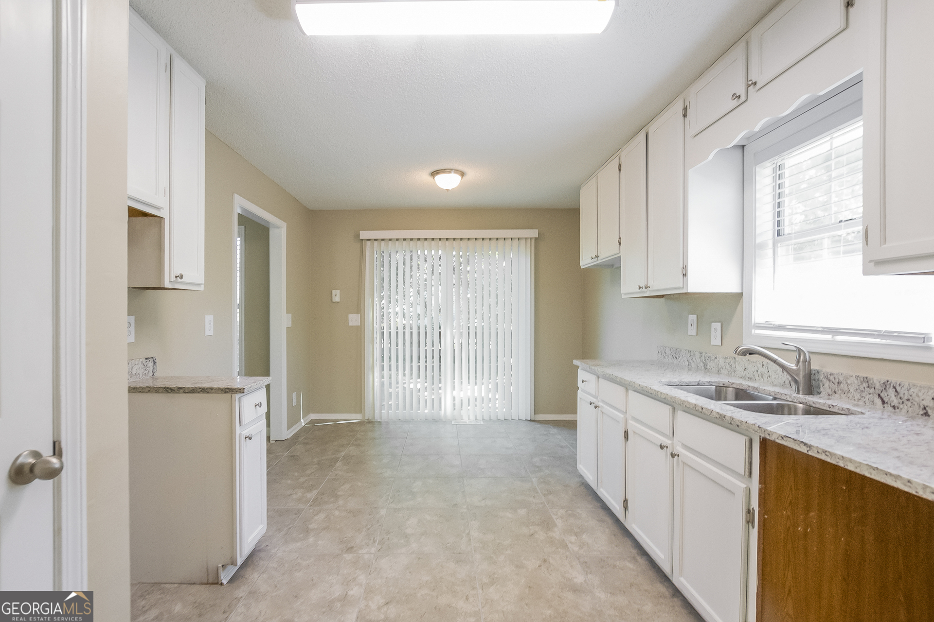2353 Loren Falls Lane Southwest Marietta, GA 30008 - Photo 6 of 17 a large kitchen with a sink window and cabinets