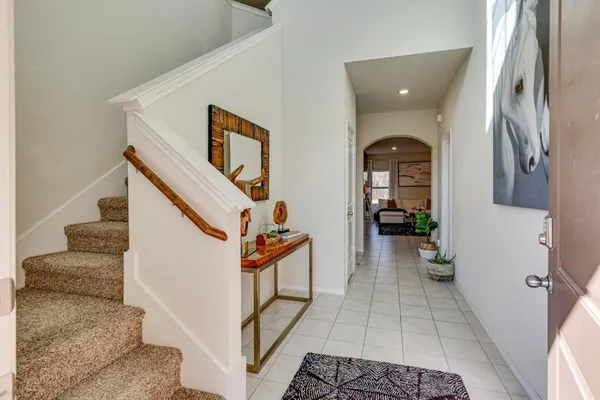 a view of a hallway with entryway and stairs
