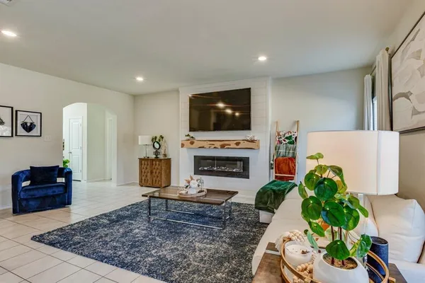 a living room with furniture a flat screen tv and a fireplace