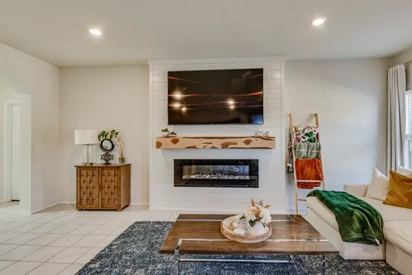 a living room with furniture a flat screen tv and a fireplace
