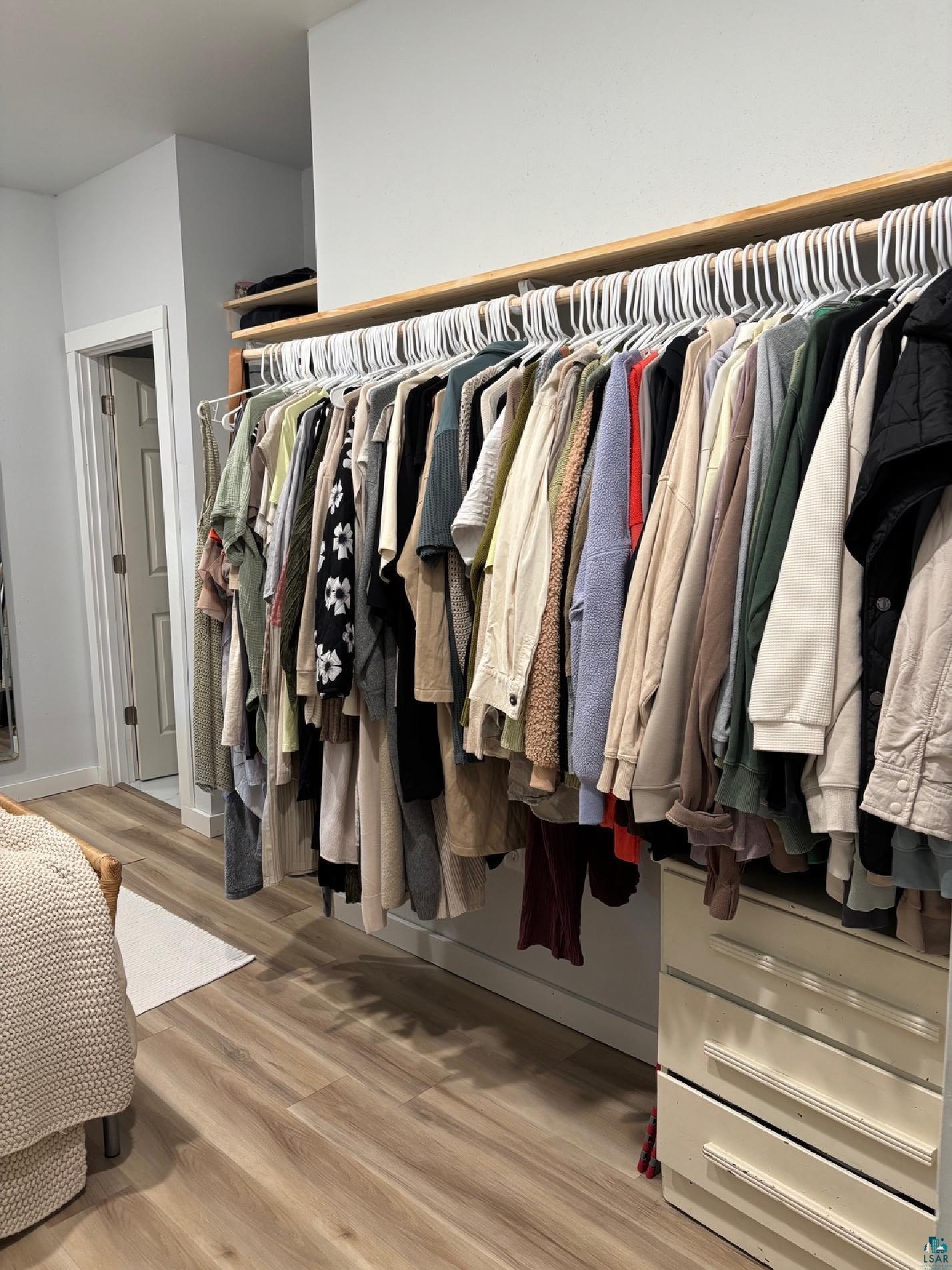 701 Drake Street Mellen, WI 54546 - Photo 25 of 27 Integrated closet system featuring light wood-finish flooring, white walls, built-in shelving, and a built-in drawer unit
