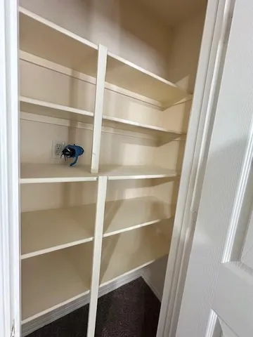 a view of walk in closet with empty racks