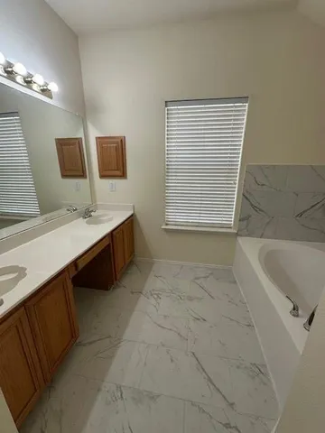 a bathroom with a tub sink and mirror