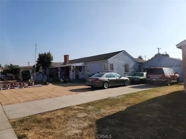 a front view of a house with cars parked
