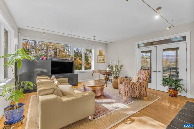 a living room with furniture and a floor to ceiling window
