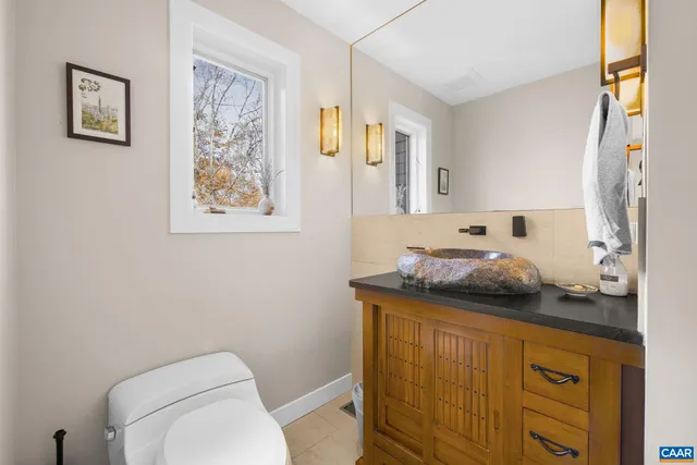 a spacious bathroom with a tub a double vanity sink a window and a mirror