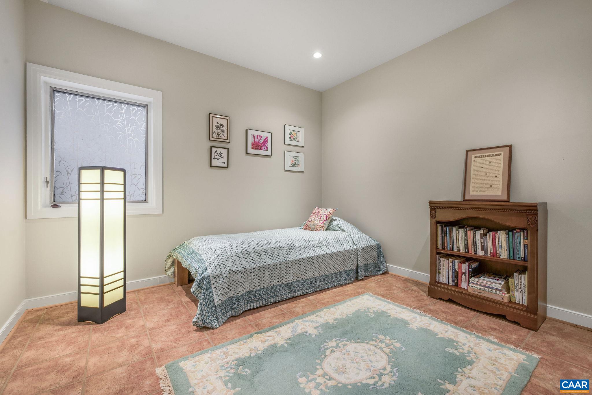 407 Broad Axe Road Charlottesville, VA 22903 - Photo 49 of 57 a spacious bedroom with a bed and a table in it