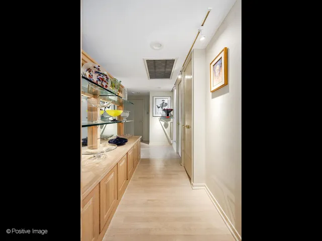 a view of a hallway with wooden floor and furniture