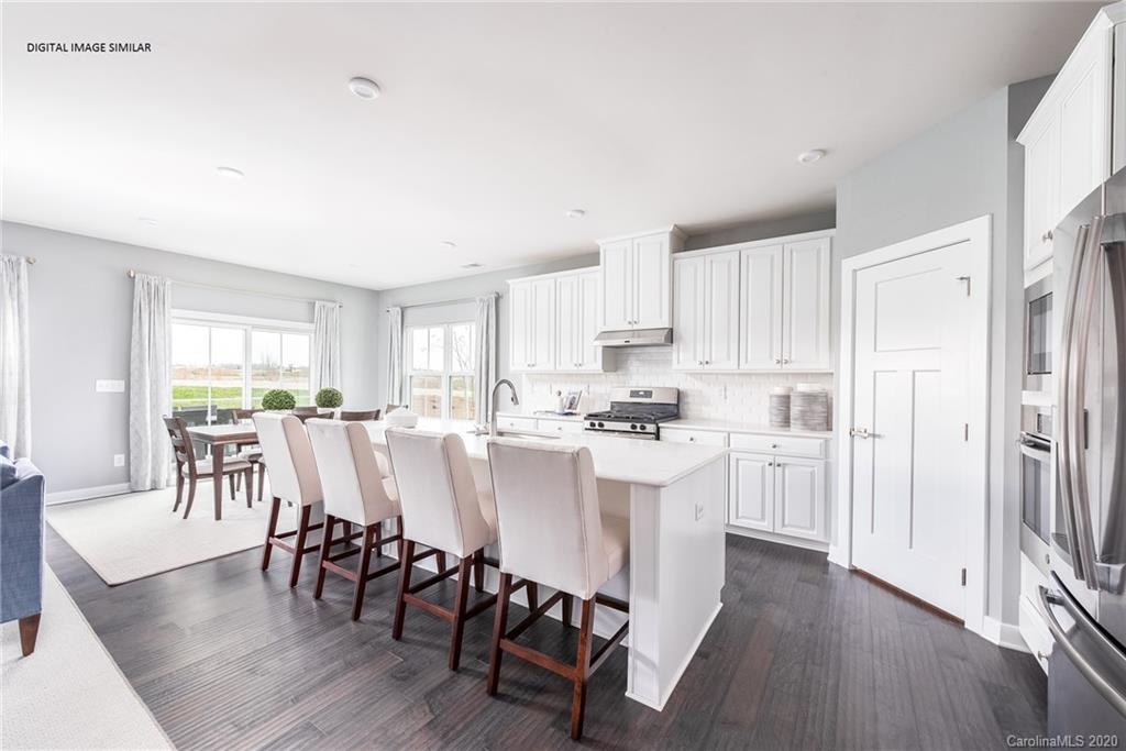 7120 Messina Road, Unit 135 Indian Land, SC 29707 - Photo 10 of 10 a kitchen with stainless steel appliances a dining table chairs and wooden floor