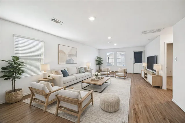a living room with furniture wooden floor and a flat screen tv