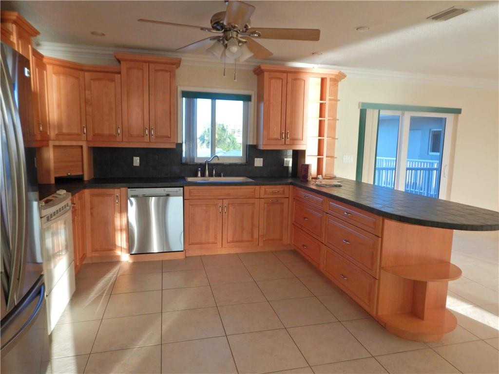 1201 South Riverside Drive, Unit PHB Pompano Beach, FL 33062 - Photo 11 of 33 a kitchen with stainless steel appliances granite countertop a sink and cabinets