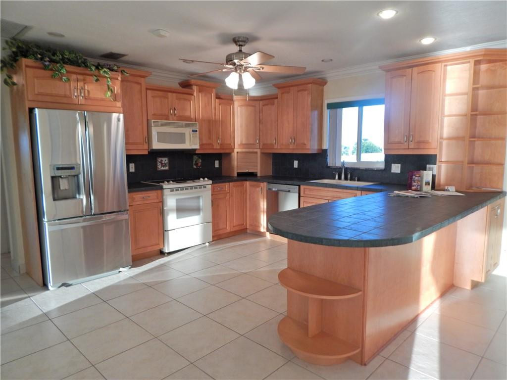 1201 South Riverside Drive, Unit PHB Pompano Beach, FL 33062 - Photo 12 of 33 a kitchen with stainless steel appliances granite countertop a sink a stove and a refrigerator