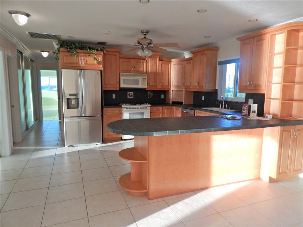 1201 South Riverside Drive, Unit PHB Pompano Beach, FL 33062 - Photo 10 of 33 a view of a kitchen with stainless steel appliances granite countertop a refrigerator and a sink