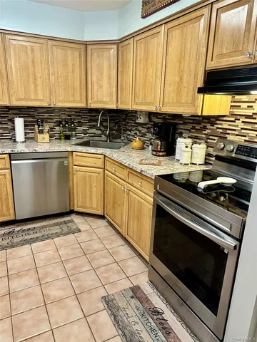 a kitchen with stainless steel appliances a stove a sink and a microwave