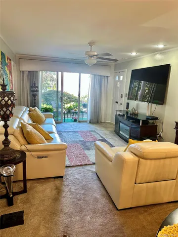 a living room with furniture a large window and a chandelier