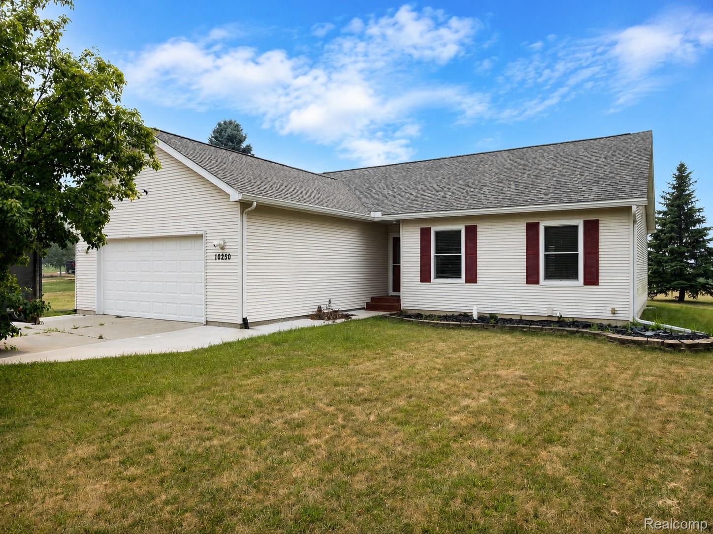 10250 Duffield Road Gaines, MI 48436 - Photo 2 of 28 Single-story residence featuring light-colored siding, a pitched roof, and an attached two-car garage