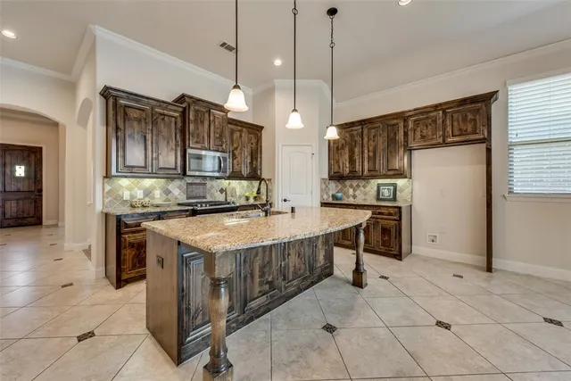 a kitchen with kitchen island granite countertop a stove a sink and a refrigerator