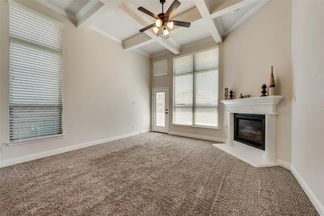 an empty room with windows and fireplace