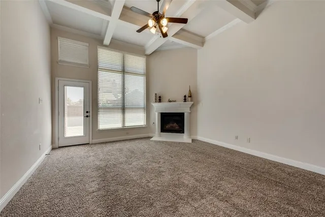 an empty room with windows and fireplace