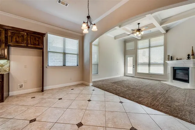 a view of an empty room with a fireplace and a window