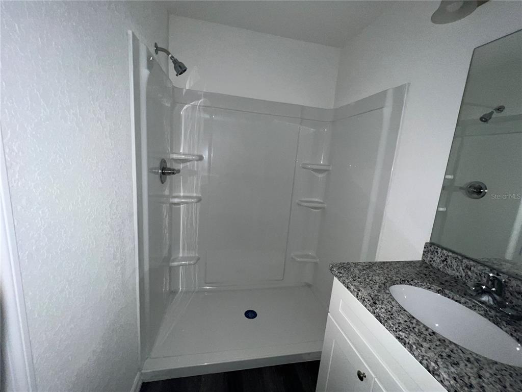 9 Maple Lane Ocklawaha, FL 32179 - Photo 23 of 26 a bathroom with a granite countertop sink a mirror and shower