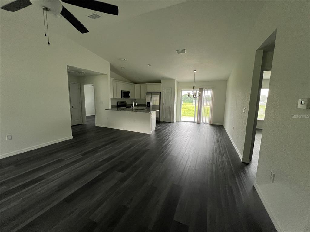 9 Maple Lane Ocklawaha, FL 32179 - Photo 5 of 26 an empty room with wooden floor and windows