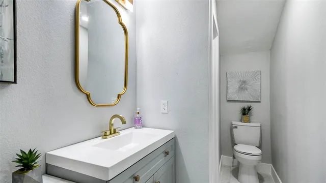 a bathroom with a sink mirror and toilet