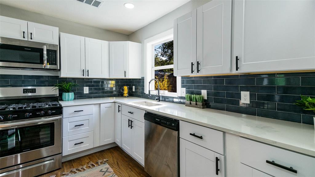 10523 Newcombe Drive Dallas, TX 75228 - Photo 8 of 25 a kitchen with stainless steel appliances white cabinets and a stove a oven with wooden floor