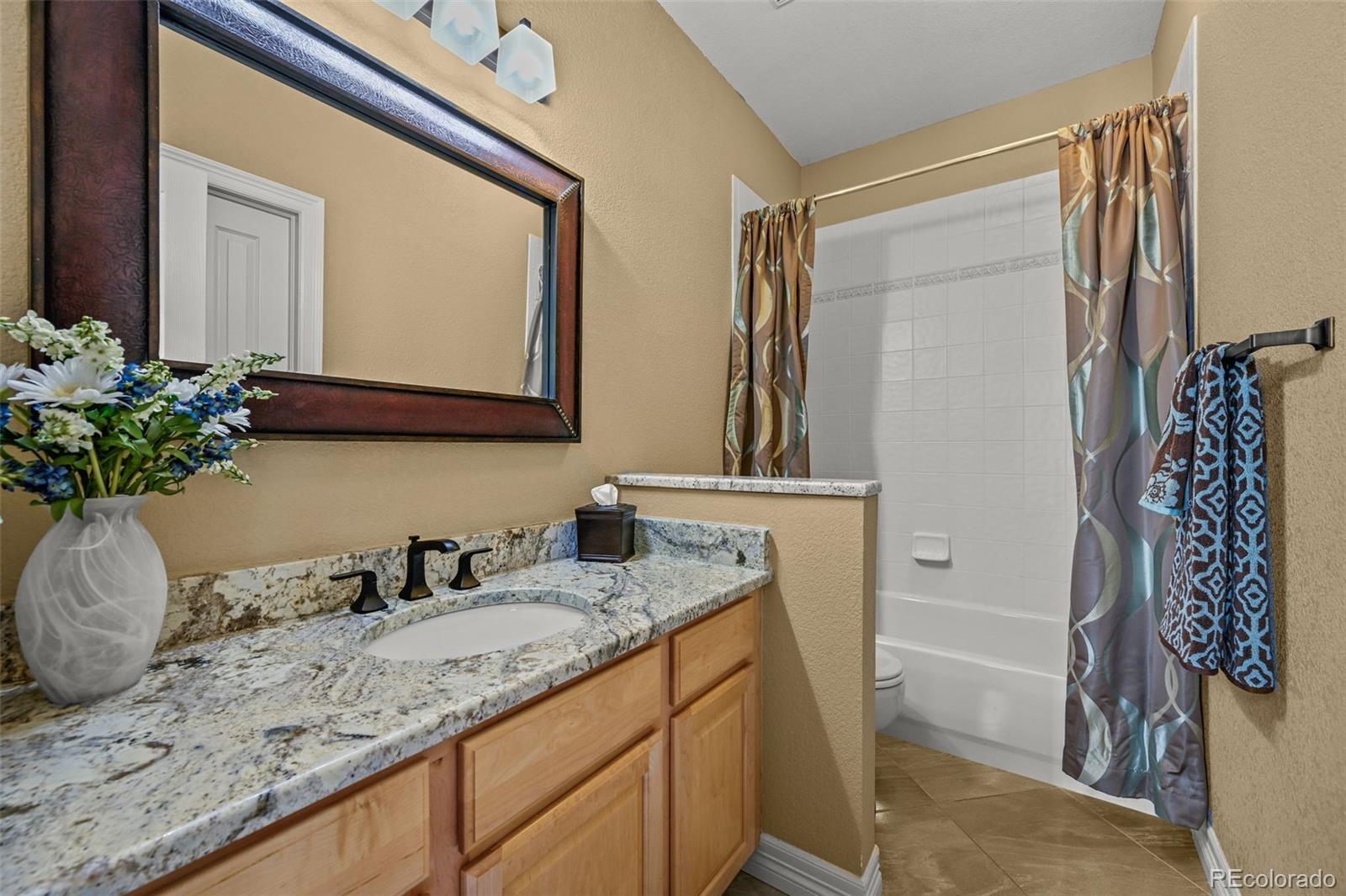 10123 Mockingbird Lane Highlands Ranch, CO 80129 - Photo 23 of 45 a bathroom with a granite countertop sink and a mirror