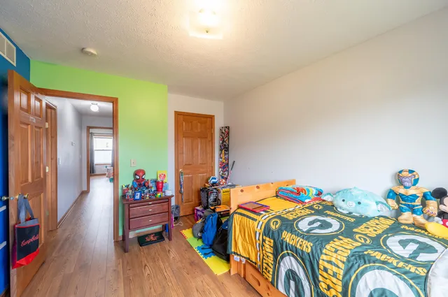 a bedroom with a bed and a wooden floor