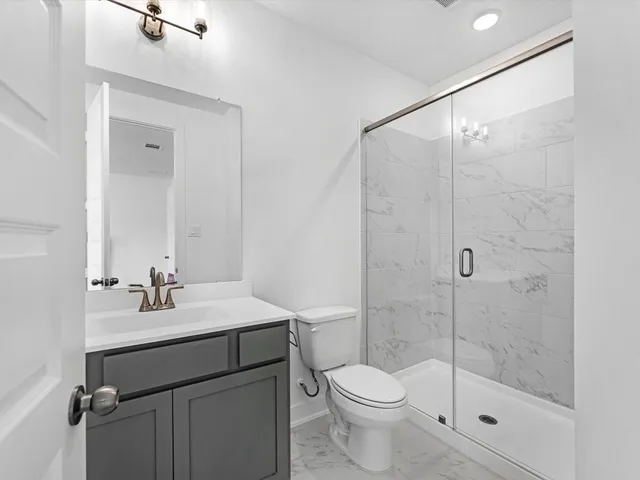 a bathroom with a sink vanity mirror and toilet