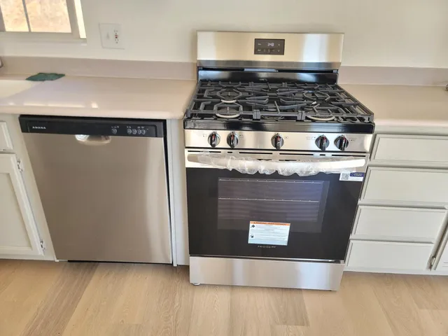 a kitchen with a stove cabinets and window