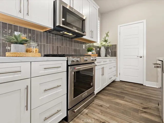 a kitchen with stainless steel appliances white cabinets and a refrigerator