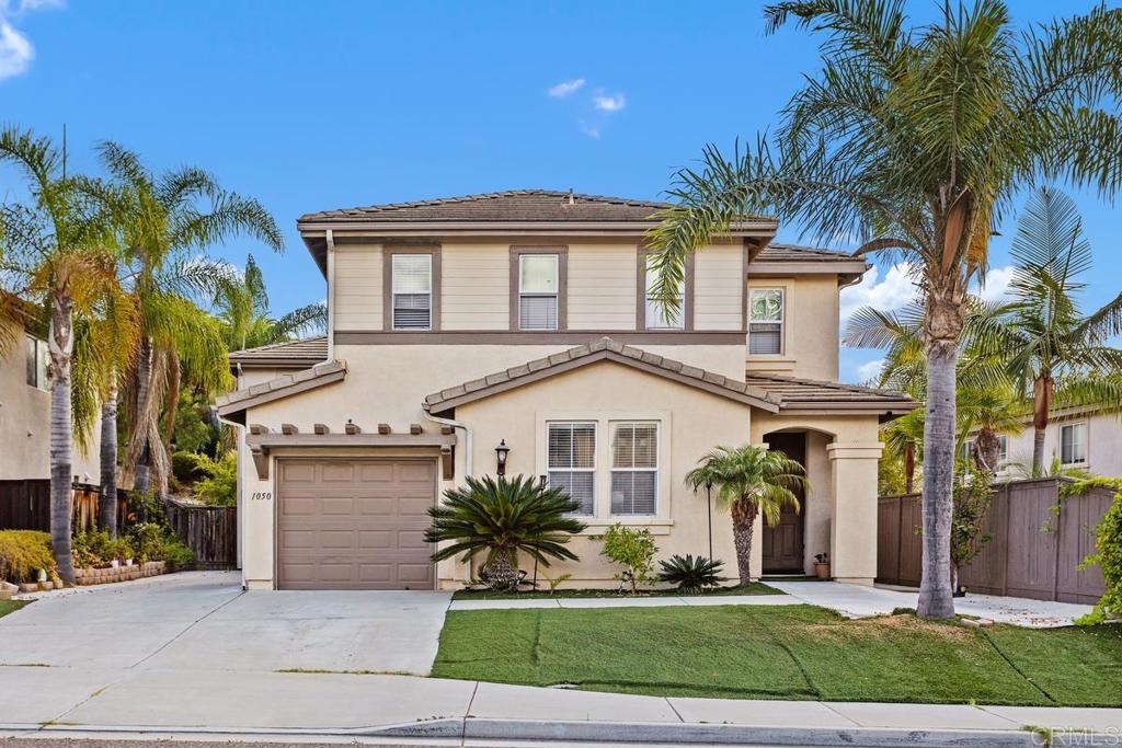 a front view of a house with a garden and palm trees