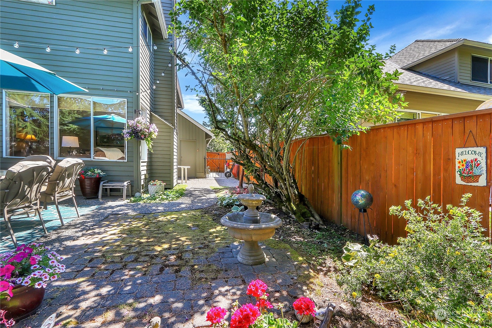 2417 240th Street Southeast Bothell, WA 98021 - Photo 35 of 40 a backyard of a house with table and chairs plants