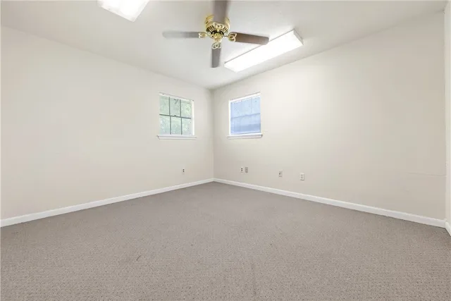 an empty room with a ceiling fan and a window