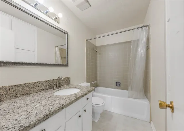 a bathroom with a granite countertop sink a toilet and bathtub