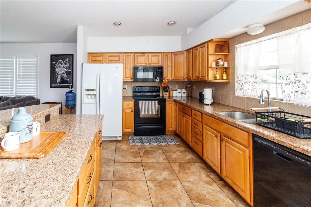 525 4th Avenue Southwest Largo, FL 33770 - Photo 11 of 27 a large kitchen with stainless steel appliances kitchen island granite countertop a sink and cabinets