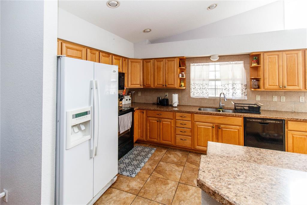 525 4th Avenue Southwest Largo, FL 33770 - Photo 6 of 27 a kitchen with stainless steel appliances granite countertop a refrigerator sink and wooden cabinets
