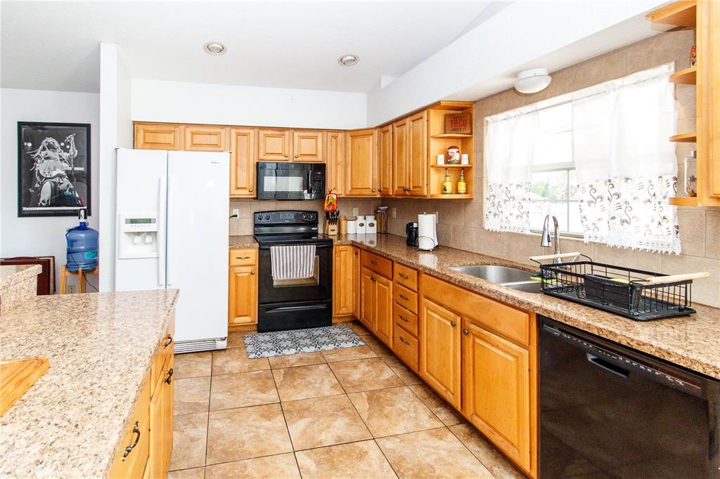 525 4th Avenue Southwest Largo, FL 33770 - Photo 8 of 27 a large kitchen with stainless steel appliances granite countertop a sink stove and refrigerator