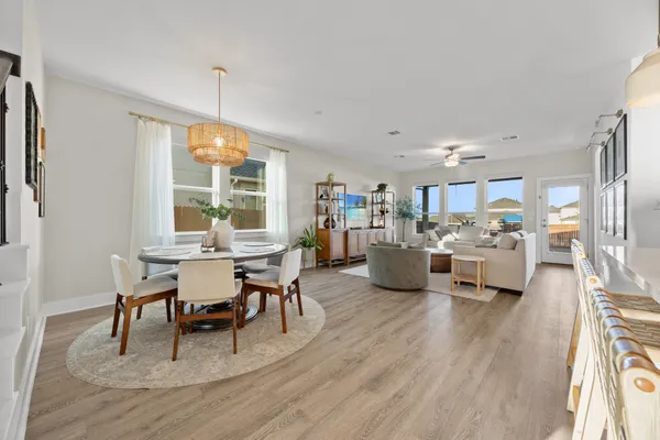 a living room with furniture a table and kitchen view
