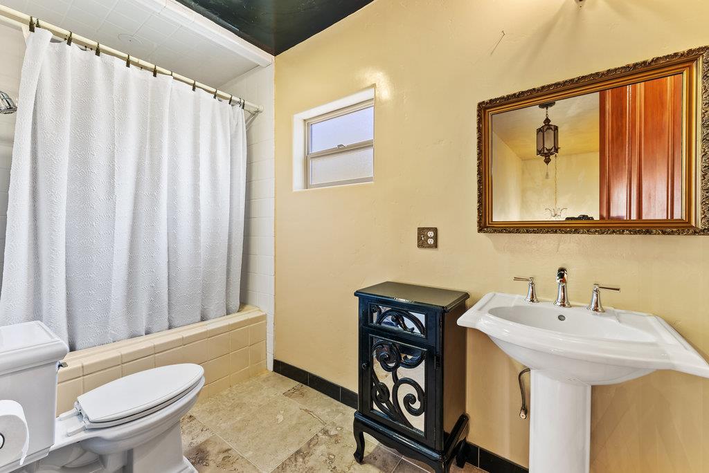 2970 Freedom Boulevard Watsonville, CA 95076 - Photo 29 of 58 a bathroom with a sink a toilet a mirror and shower curtain