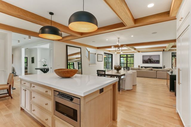 a room with stainless steel appliances kitchen island a large counter space cabinets and wooden floor