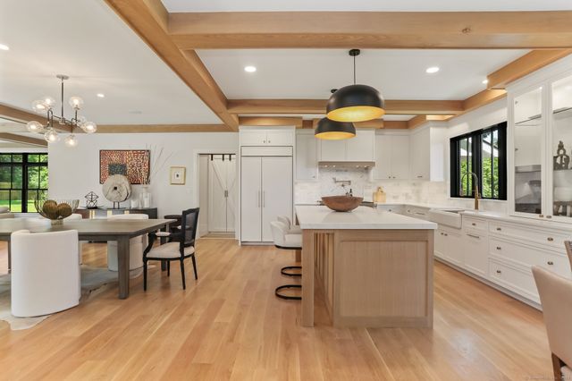 a kitchen with kitchen island granite countertop a stove and a wooden floors