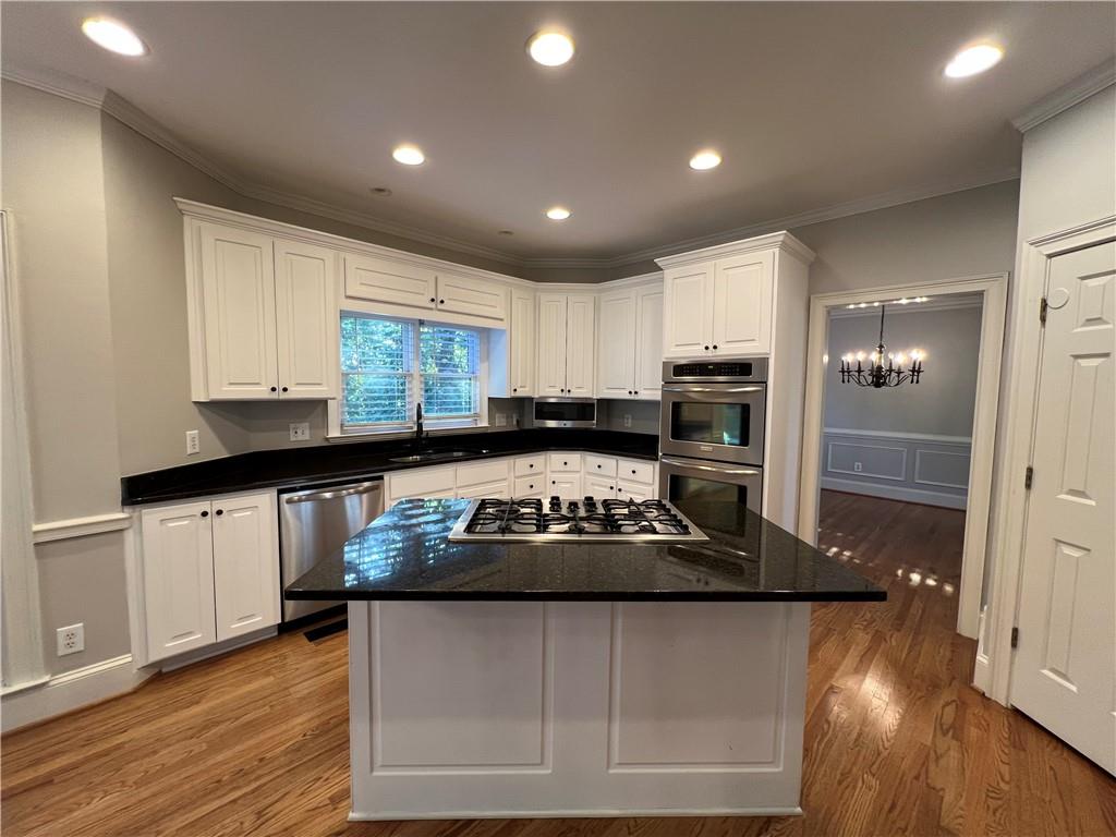 Undisclosed Address Kennesaw, GA 30144 - Photo 14 of 51 a kitchen with kitchen island granite countertop a stove sink and cabinets