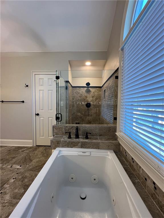 Undisclosed Address Kennesaw, GA 30144 - Photo 26 of 51 a bathroom with a bathtub and a shower