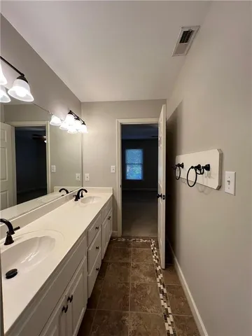 a spacious bathroom with a double vanity sink and mirror with shower