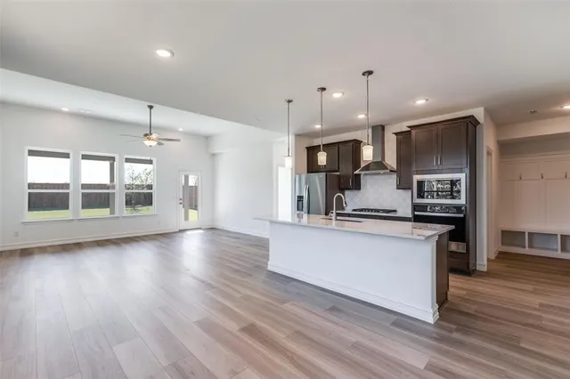 a large kitchen with stainless steel appliances kitchen island a large counter top and a wooden floors